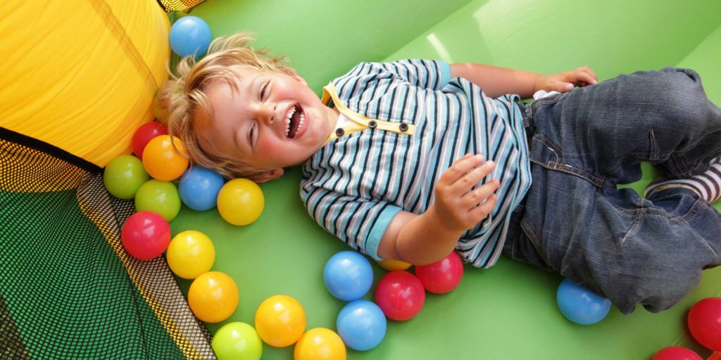 a child laughing in a ball pit