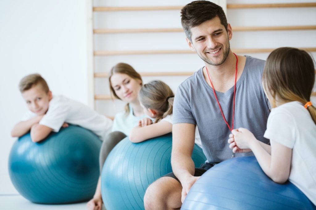 Staff member with kids on large exercise balls