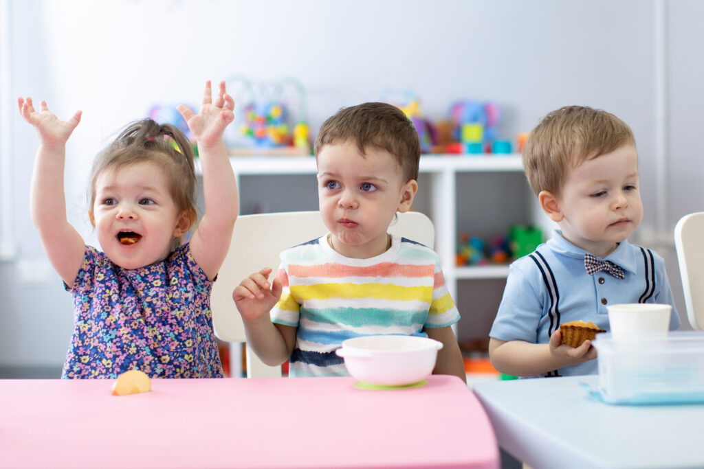 Toddlers eat lunch.