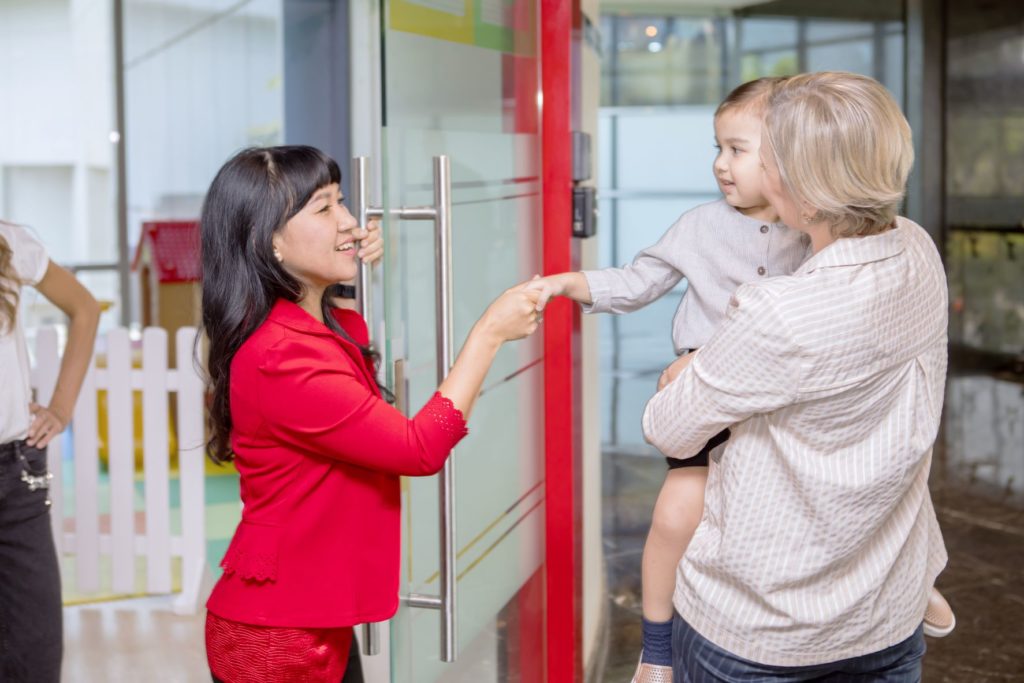 Daycare owner greets prospective family.