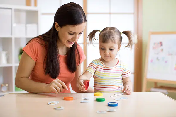 Daycare teacher and child learning about shapes and colors