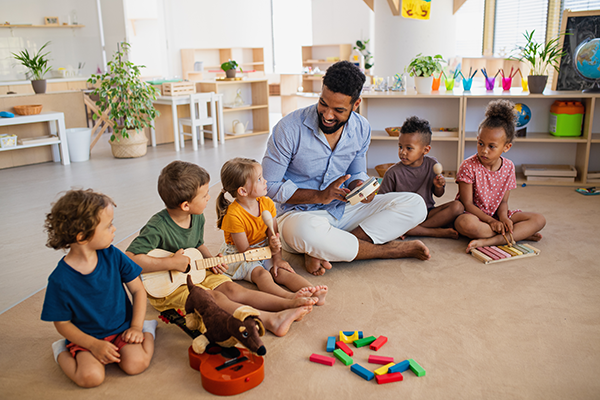 Preschool students play music on instruments.