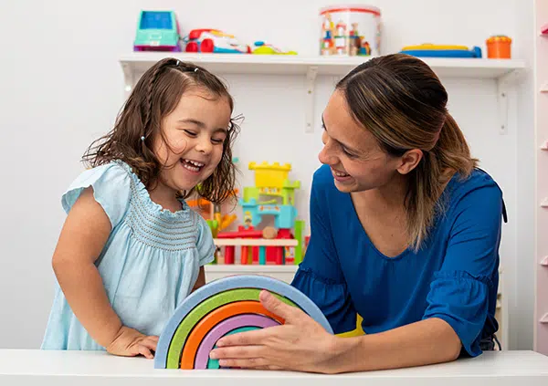 teacher plays with a student in a daycare classroom