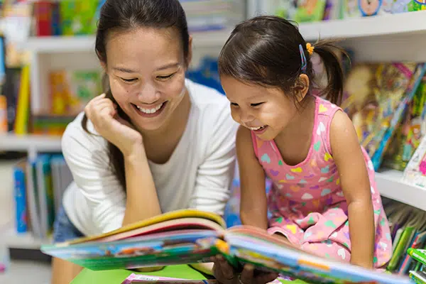 Teacher reads to young child.