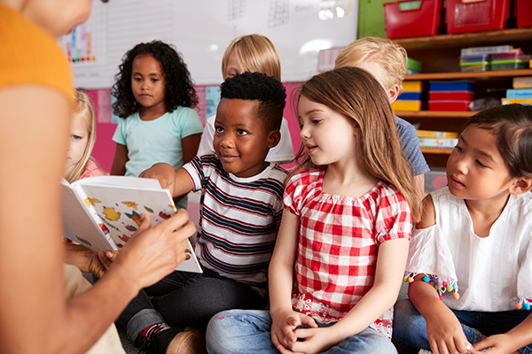 Teacher reads to preschool class in a daycare.