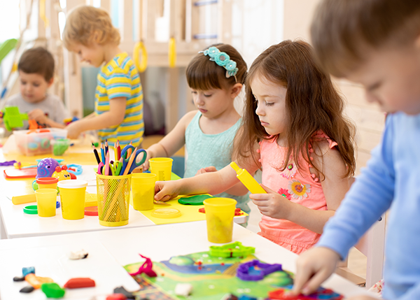 Young children complete an art project in child care.