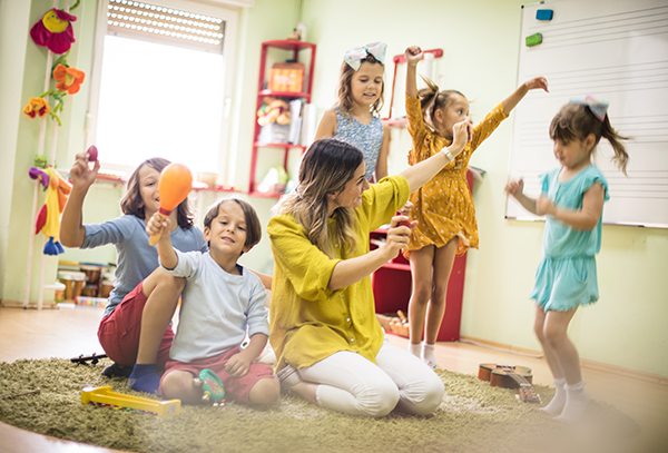 Preschool teacher leads a music class.