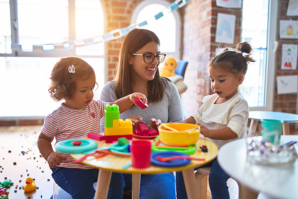 Woman plays with toddlers.