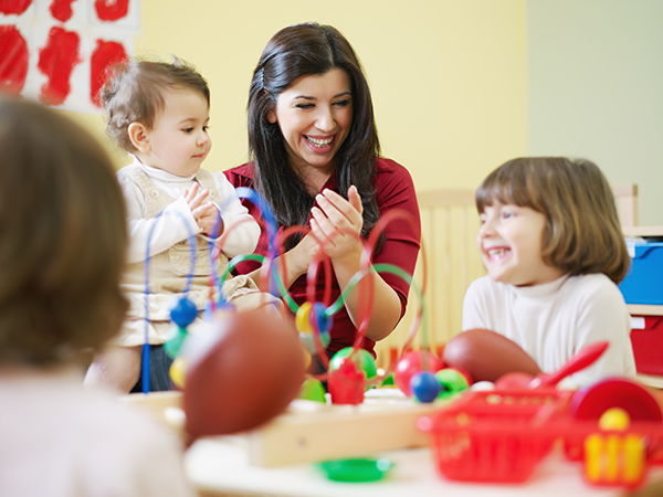 Teacher plays with children in a child care center.