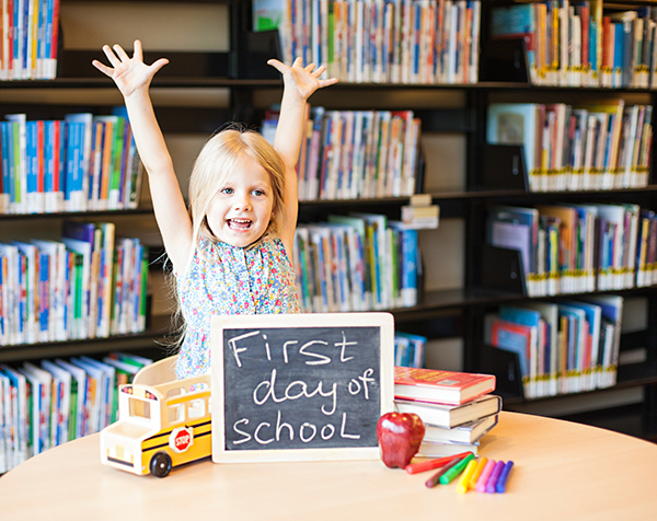 Preschool girl celebrates her first day of school.