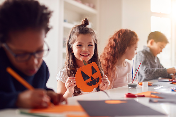 Preschool girl shows her Halloween craft.