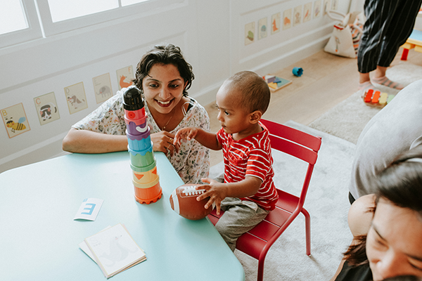 Teacher spends one-on-one time with young boy, building blocks.