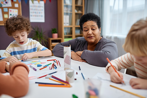 Teacher observes young children in the classroom.